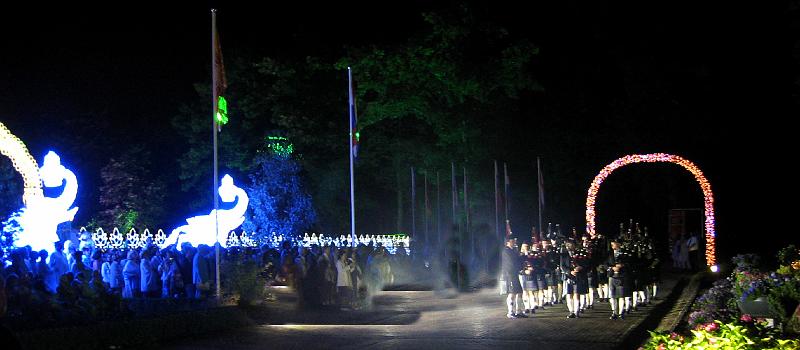 GP8 - bagpipers.jpg - MERU, the Netherlands: The thrilling skirl of bagpipes leading the procession in the lighted gardens adds to the Guru Purnima Celebration.